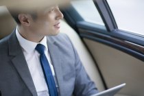 Китайский бизнесмен сидит на заднем сидении автомобиля — стоковое фото