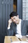 Chinese sitzt und lächelt im Restaurant — Stockfoto