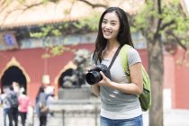 Mujer china visitando Lama Temple con cámara digital - foto de stock
