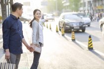 Maturo coppia cinese gesticolando in strada con borse della spesa — Foto stock
