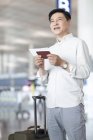 Reifer Chinese wartet mit Ticket am Flughafen — Stockfoto