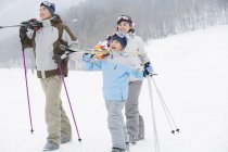 Chinesische Eltern mit Sohn zu Fuß mit Skiern auf Schultern im Skigebiet — Stockfoto