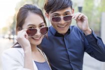 Couple chinois posant avec des lunettes de soleil — Photo de stock