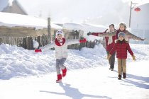 Nonni cinesi che corrono nella neve con bambini — Foto stock