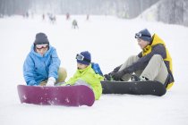 Chinese parents wearing snowboarding gear on son — Stock Photo