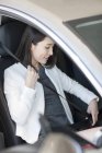 Young chinese woman fasting belt in car — Stock Photo