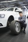 Chinesischer Automechaniker hält Autorad in Werkstatt — Stockfoto