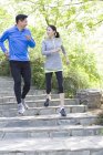 China pareja madura corriendo en las escaleras en el parque - foto de stock