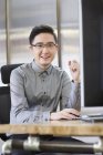 Cinese maschio IT lavoratore seduto sul posto di lavoro — Foto stock