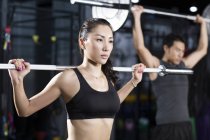 Chinese athletes lifting barbells at gym — Stock Photo