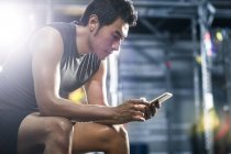 Chinese benutzt Smartphone im Fitnessstudio — Stockfoto