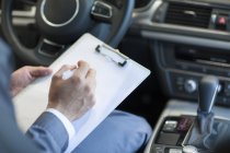 Close-up of auto mechanic making notes in car — Stock Photo