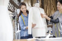 Chinoise tailleurs travaillant avec mannequin en studio — Photo de stock
