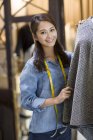 Chinese female fashion designer standing in shop — Stock Photo
