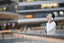 Китайская бизнесвумен разговаривает по телефону в финансовом районе — стоковое фото