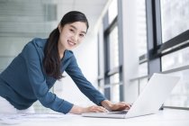 Empresária chinesa usando laptop no escritório — Fotografia de Stock