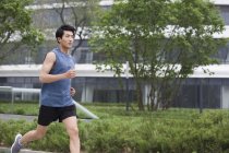 Chinese man jogging on street — Stock Photo