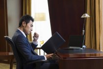 Chinese businessman working in home office — Stock Photo
