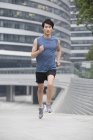 Chinese man running on street — Stock Photo
