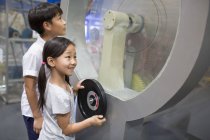 I bambini cinesi che guardano e interagiscono a mostra in museo — Foto stock