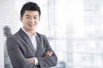 Hombre de negocios chino con los brazos cruzados - foto de stock