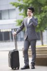 Китайський бізнесмен, говорити по телефону з чемодан — стокове фото