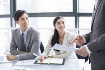 Chinese business people talking at meeting — Stock Photo