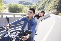 Chinese couple sitting on motorcycle together — Stock Photo