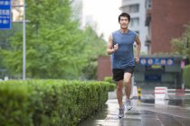 Chinese man jogging on street — Stock Photo