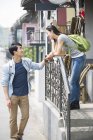 Casal chinês de pé nas escadas e falando — Fotografia de Stock
