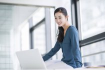 Китайская предпринимательница использует ноутбук в офисе — стоковое фото