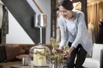 Mature Chinese woman arranging flowers in boutique — Stock Photo