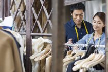 Chinesische Modeschöpfer wählen Kleidung aus dem Regal im Atelier — Stockfoto