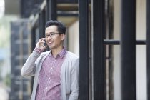 Uomo cinese che parla al telefono per strada — Foto stock