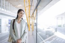 Mulher chinesa madura esperando no aeroporto em olhar para a vista — Fotografia de Stock