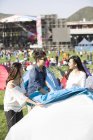 Amici cinesi che allestiscono una tenda sull'erba — Foto stock