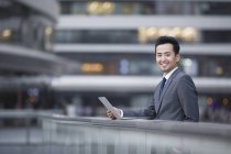 Chinesischer Geschäftsmann mit Laptop auf der Straße — Stockfoto
