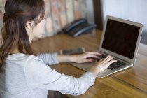 Китаянка использует ноутбук в офисе — стоковое фото