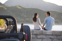 Couple chinois assis au bord du lac en banlieue — Photo de stock