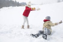 Niños chinos teniendo pelea de bolas de nieve en el parque - foto de stock