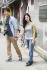 Chinese couple standing on street with camera — Stock Photo