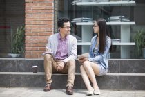 Chinese colleagues sitting and talking on street — Stock Photo