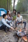 Chinesische Freunde sitzen am Lagerfeuer und trinken Bier — Stockfoto