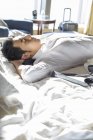 Китайский бизнесмен отдыхает на кровати в гостиничном номере — стоковое фото