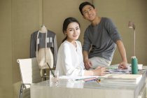Diseñadores de moda chinos sentados en el escritorio - foto de stock