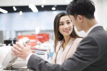 Chinese couple choosing multicooker in electronics store — Stock Photo