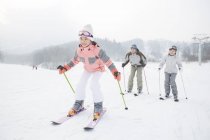 Китайская семья с дочерью катается на лыжах на горнолыжном курорте — стоковое фото