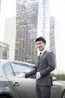 Chauffeur chinois faisant un geste accueillant en voiture — Photo de stock
