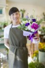 Chinese florist holding bouquet of flowers — Stock Photo