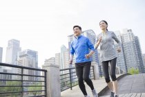 Chinese mature couple running in city — Stock Photo